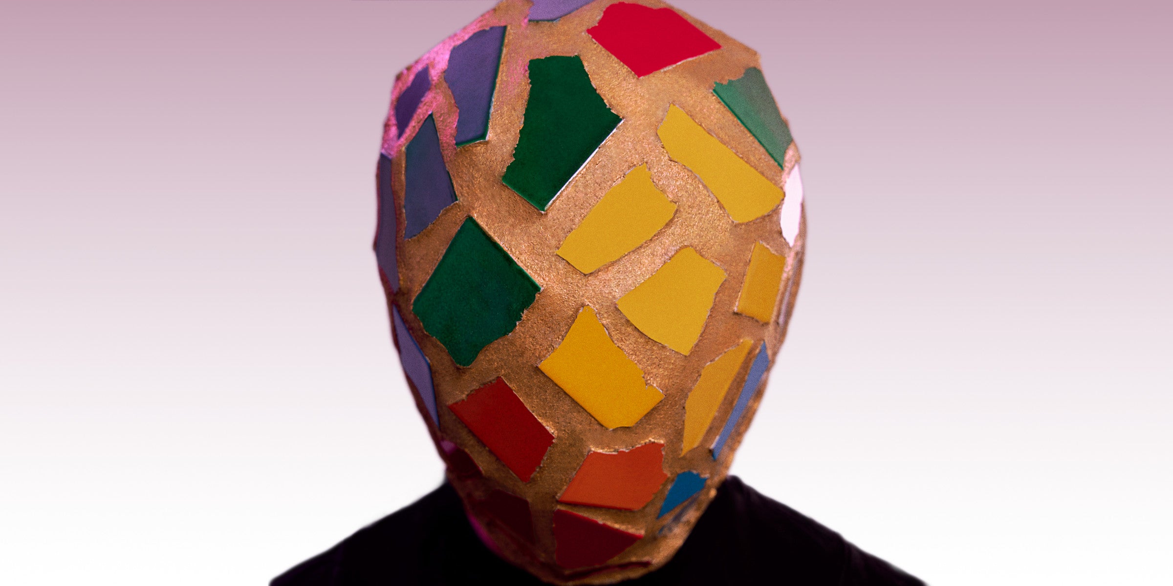 The king of dreams wearing a colorful geometric-patterned mask from MAIVUS