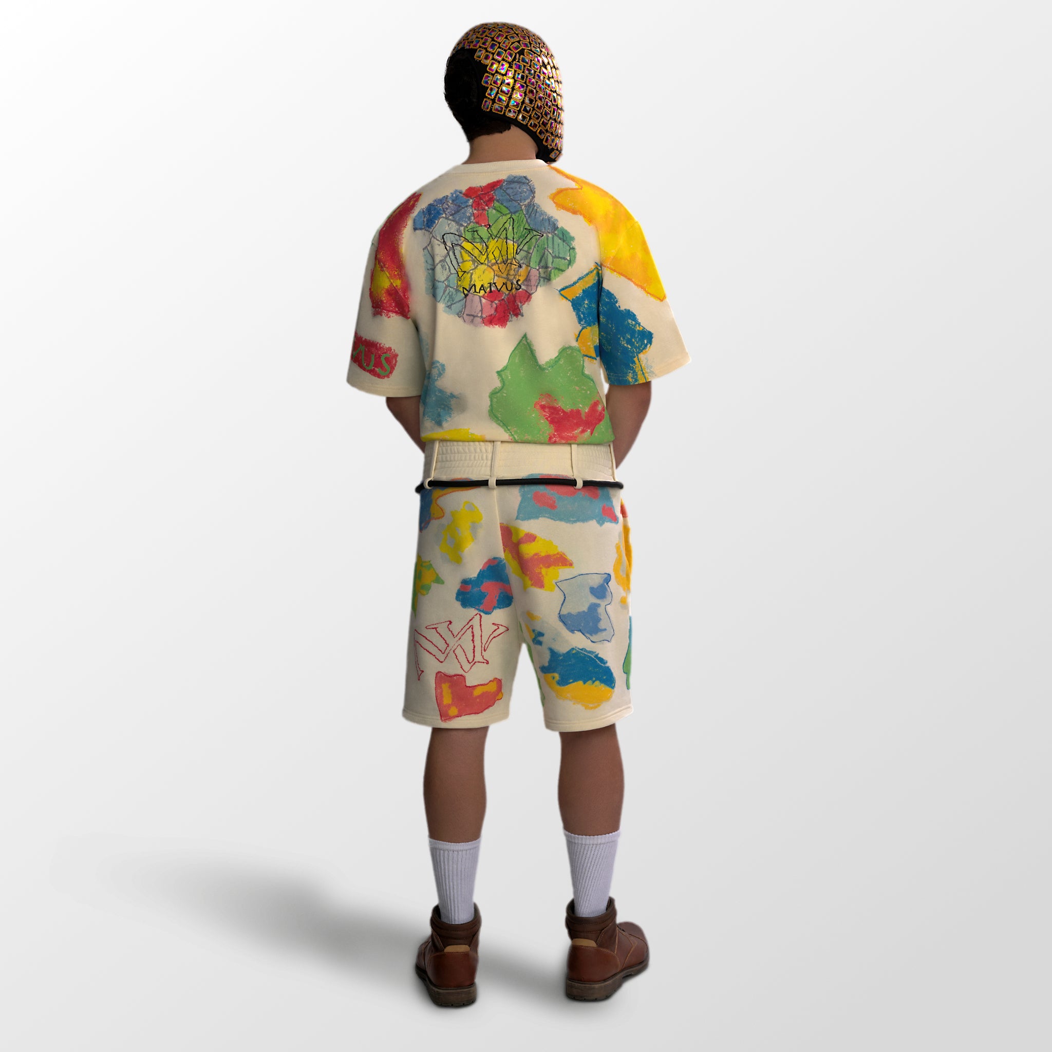 Model wearing the luxury multicolored t-shirt and shorts with abstract shapes and 'MAIVUS' branding from 'MAIVUS' against a white studio backdrop