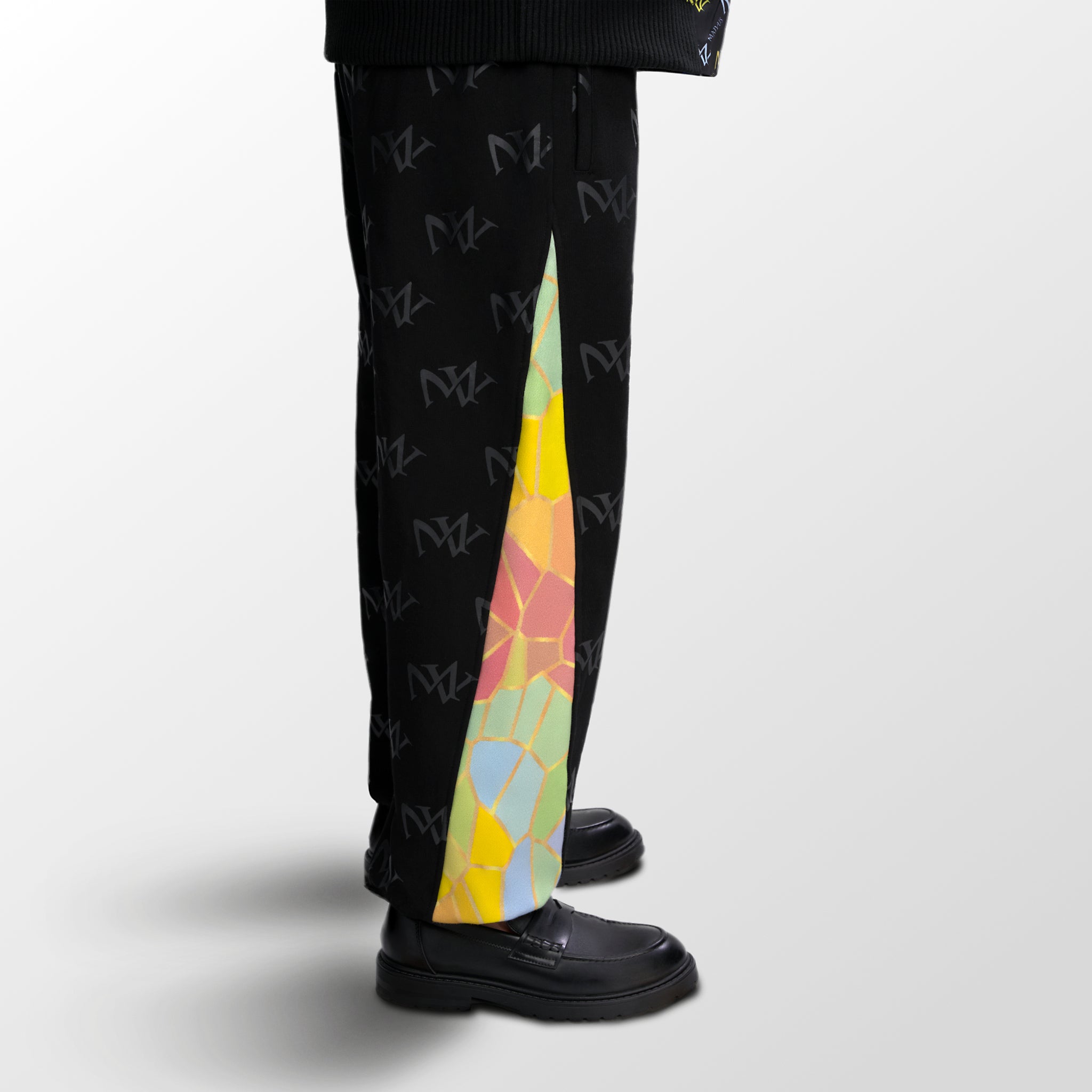 Model wearing the luxury multicolored  joggers with 'MV' branding and geometric shapes from 'MAIVUS' against a white studio backdrop