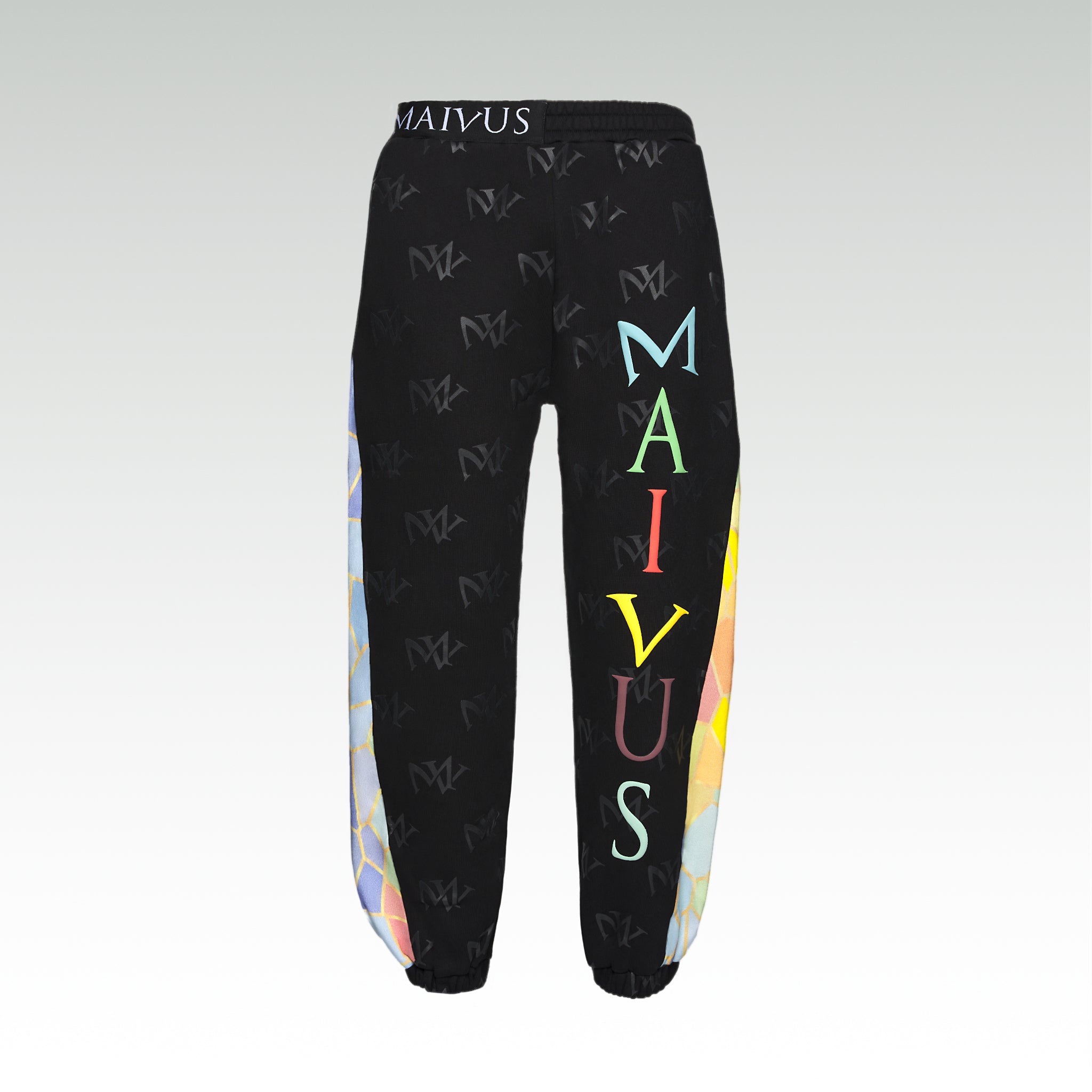 Close up of the luxury multicolored joggers with 'MV' branding and geometric shapes from 'MAIVUS' against a white studio backdrop
