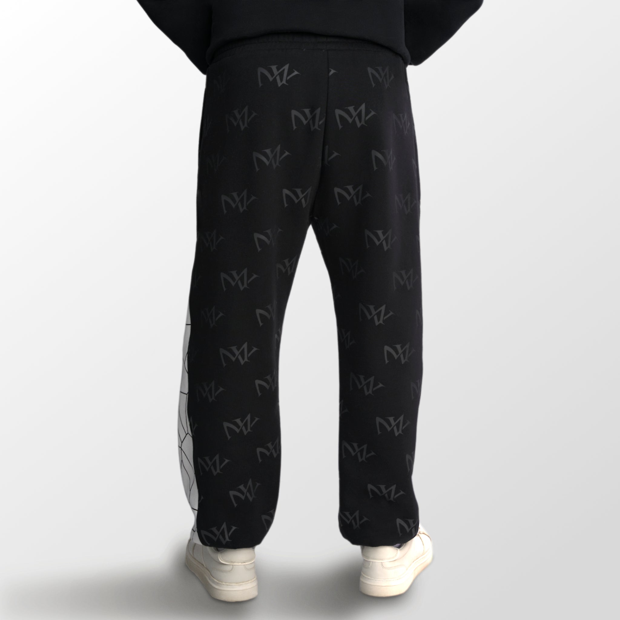 Model wearing the luxury white and black joggers with 'MV' branding and geometric shapes from 'MAIVUS' against a white studio backdrop